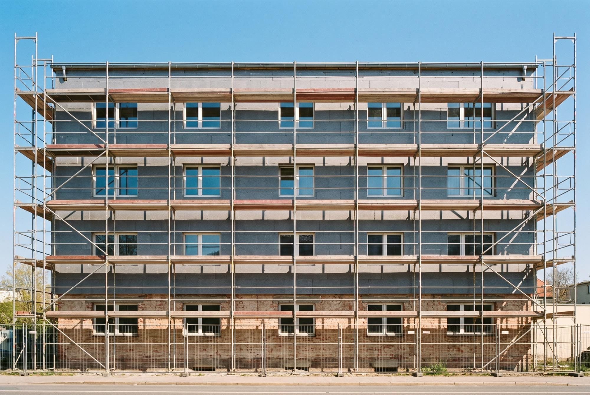 Eingerüstetes Wohnhaus mit frisch montierten Dämmplatten während der energetischen Sanierung