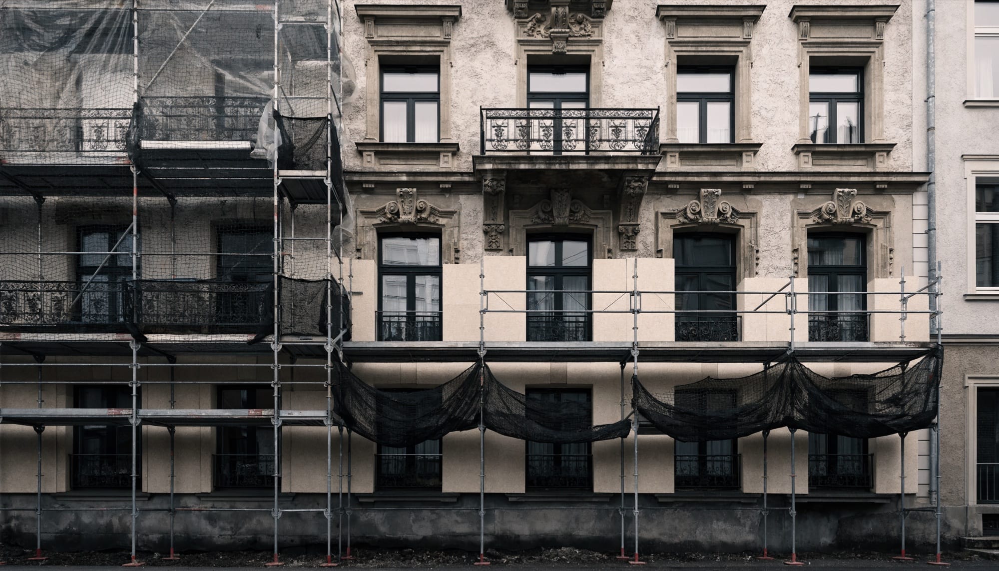 Gerüst mit frisch angebrachten Dämmplatten an der Fassade eines Altbaus während der energetischen Sanierung